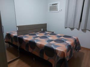 奥林匹亚Apartamento Olimpia - Próximo ao Parque Thermas dos Laranjais - Ideal para familias的一张带图案毯子的床铺