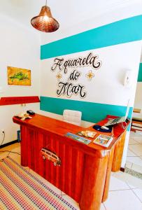 阿布拉奥Pousada Aquarela do Mar的墙上有标牌的桌子