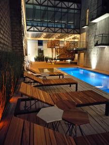 乔卢拉Hotel Tila的一座带木桌和椅子的游泳池,位于一座建筑旁边