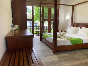 米瑞莎Handagedara Resort & Spa的一间卧室配有两张床和一张带天鹅的书桌。