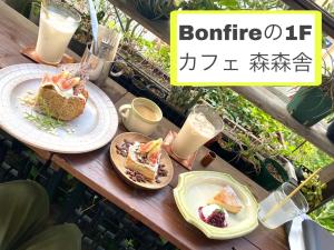 大阪大阪篝火旅舍的一张桌子,上面放着两盘食物和饮料