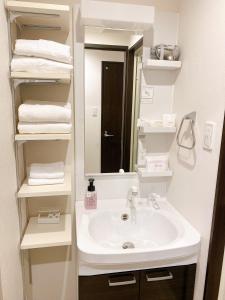 那霸KOHALA　HOTEL的浴室配有盥洗盆、镜子和毛巾