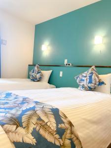 那霸KOHALA　HOTEL的一间卧室设有两张带蓝色墙壁的床