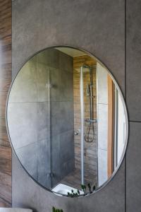 乔尔什滕Domek nad zalewem的浴室设有圆形镜子和淋浴