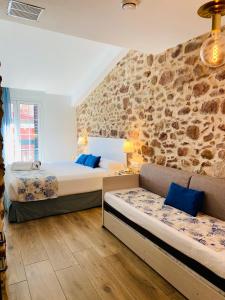 贝尼卡西姆Soléa House Hotel Boutique的一间卧室设有两张床和石墙