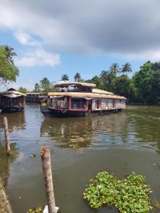 阿勒皮Johnson's Homestay - Ecohouseboat的船停靠在河上