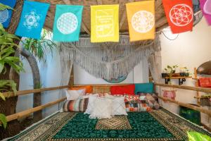日惹日惹乐佛旅舍的客房设有一张带色彩缤纷枕头和旗帜的床。