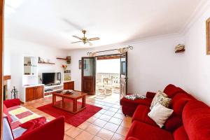 蒂亚斯Casa Bellavista的客厅配有红色的沙发和桌子