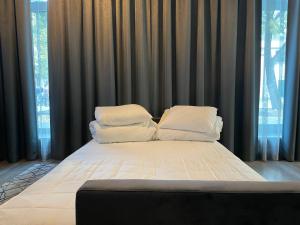 考纳斯Daukanto 5的配有窗户的客房内的一张带白色床单和枕头的床