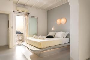 TagouYalos mykonos 3 bedroom Luxury home in Mykonos Town with Sea & Sunset view的白色的卧室设有床和大窗户