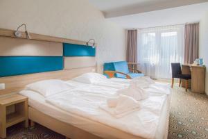 尤斯托尼莫斯基Imperiall Resort & MediSpa的一张大白色的床,位于酒店客房内