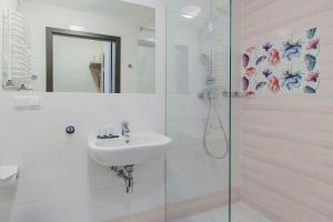尤斯托尼莫斯基Imperiall Resort & MediSpa的白色的浴室设有水槽和淋浴。