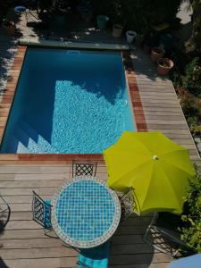 滨海萨纳里L'Ecrin d'Azur的一个带绿色遮阳伞和两把椅子的游泳池