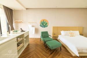 五结Wonderwall美好境界 宜兰五结馆 的一间卧室配有一张床和两张绿色椅子