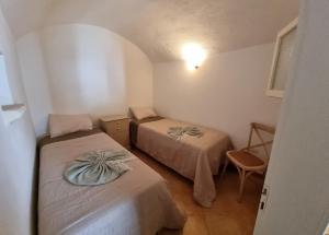 莱乌卡Casa a Santa Maria di Leuca的小房间设有两张床和椅子