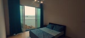 峇六拜Infinite Seaview with Penang Bridge Suite with Sunrise up to 11 person的一间卧室设有一张床和一个大窗户