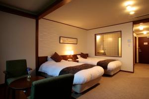 千岁Shikotsuko Onsen Lake Side Villa SUIMEIKAKU-Adult Only的酒店客房设有两张床和一张桌子。