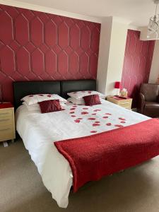 史云顿Brewery Farm House Bed & Breakfast的一间卧室配有一张大床和红色床头板