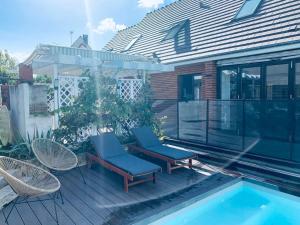 拉沙佩勒Appartement proche Astérix, Stade de France, Chantilly, Roissy, piscine saisonnière的一个带两把椅子的庭院和一个游泳池