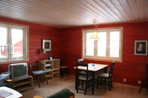 Bjällum霍尔波阿琼斯度假屋的一间拥有红色墙壁、桌子和电视的用餐室