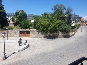 蓬费拉达Apartamento en el casco antiguo de Ponferrada的庭院内有两座雕像的石墙