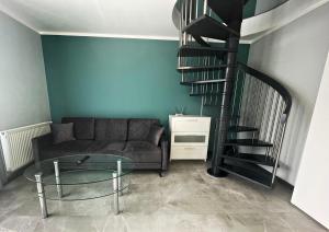 米兹多洛杰Marea by Baltic Home的带沙发和螺旋楼梯的客厅