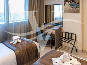 沙迦Viola Hotel Apartments的酒店客房设有两张床和一张桌子。
