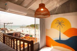 弗洛里亚诺波利斯Sea Wolf Surf Hostel的卧室设有窗户,享有海滩美景