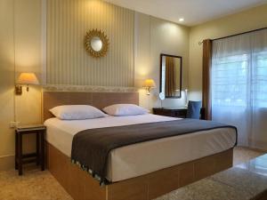 卡伦海滩Holiday Village And Natural Garden Resort的一间卧室配有一张大床和镜子