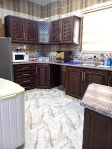 杰拉什Furnished apartment for rent in jarash شقة مفروشة للإيجار في جرش的一间铺有大理石地板并配有木制橱柜的厨房
