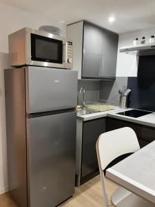 Village-NeufChouett'Appart proche frontières的厨房配有不锈钢冰箱和微波炉。