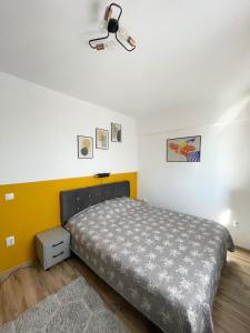 雅西Cozy Apartment - near Airport and Palas Mall的一间卧室设有一张床和黄色的墙壁