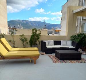 雅典INSPIRATION Guestroom with Amazing Roof Garden的阳台的天井配有沙发和椅子