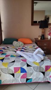 危地马拉apartamento 407 zona 9的床上有五颜六色的被子和毛巾