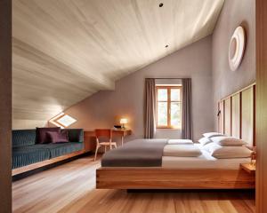 施科佩尔瑙阿德尔酒店的一间卧室配有一张大床和一张沙发