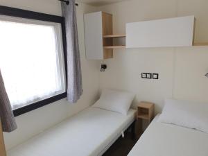 鲁西隆地区卡内Mobilhome camping le MAR ESTANG的小型客房 - 带2张床和窗户
