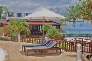 桑给巴尔Royal Cliff Zanzibar的一个带椅子和遮阳伞的庭院