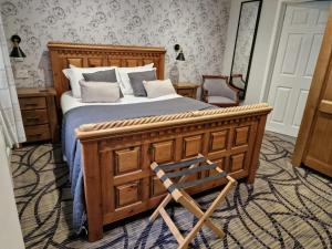 法弗舍姆Country Retreat at Judd's Folly的一间卧室配有木床和木椅