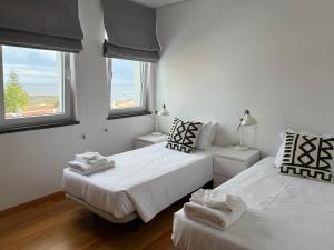 英雄港Casa dos Remedios的白色客房的两张床,设有两扇窗户