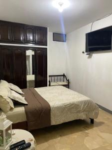 曼塔Departamento amoblado centro Manta的一间卧室配有一张床和一台平面电视