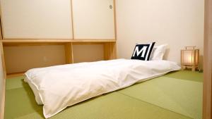 大阪東瀛Stays402奈良　お洒落な和洋室的一张白色的床,上面有椅子