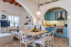 米克诺斯城Yalos Mykonos Ornos Pouli private apartments w shared swimming pool的厨房配有蓝色橱柜和桌椅