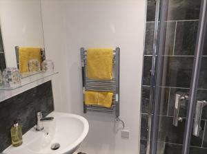 利物浦Victorian Renovation Room 8的浴室设有水槽和带黄毛巾的淋浴。