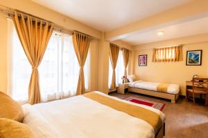 帕坦Bhrikuti Stay的酒店客房设有两张床和窗户。