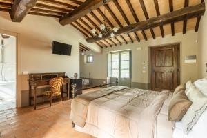 蒙特普齐亚诺Agriturismo Merigge Wellness & Spa Montepulciano的一间卧室配有一张大床和一张书桌