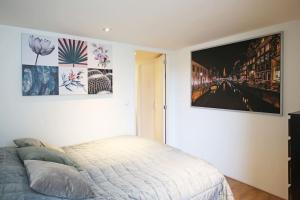 皮尔默伦德Appartementen Purmerend B的卧室配有一张床,墙上挂着一幅画
