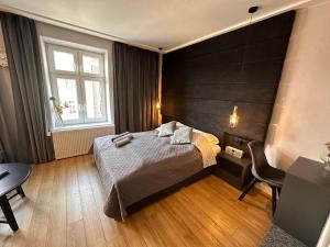 奥尔什丁DK Premium Mendelsohna的一间卧室配有一张床、一张书桌和一个窗户。