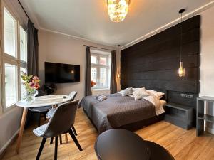 奥尔什丁DK Premium Mendelsohna的一间卧室配有一张床、一张桌子和一台电视