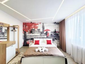 普里什蒂纳Cozy Apartment in Pristina的卧室配有一张床,墙上挂有绘画作品