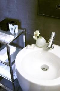 海牙城市住宿旅馆的浴室设有白色水槽,上面有花